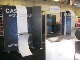 eSmart Custom Exhibit with Aluminum Extrusion Frame, Laminate Shelves, Sintra Header Graphics, SEG Fabric Fraphics, LED Luminators, Custom Podium, and Monitor Mounts. Converts to 10x10 -- Image 1