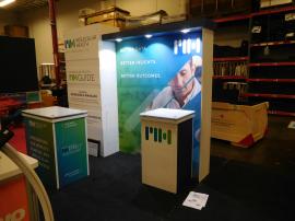 Custom Modular Inline Exhibit with Laminate Panels, SEG Graphic, Puck Lights, and (2) Modular Laminate Counters with Locking Storage