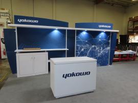 Modified VK-2928 Modular Exhibit with Monitor Mount, Backwall Counter, Shelves, Puck Lights, Curved Header Graphics, and MOD-1596 Custom Counter with LED Lights and Locking Storage
