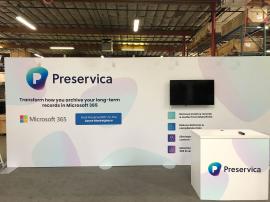 RENTAL: Modified RE-2141 Inline Design with 232" Wide x 96" High Extrusion Backwall with Large Monitor Mount with Internal Extrusion Supports, 43" Monitor, RE-1202 Reception Counter with White Laminated Top, (4) LED Arm Lights, SEG Fabric Graphic, Direct