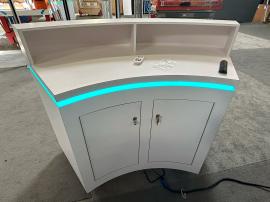 RENTAL: RE-1598 White Laminated Reception Counter with Riser, LED/RGB Recessed Lighting, SEG Fabric Graphics, and Vinyl Applied Graphic