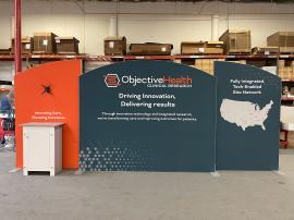 Customized 10 x 20 Symphony Portable Display with SEG Fabric Graphics, Monitor Mount, SYM-407B Backwall Counter with Locking Storage, and MOD-1703 Reception Counter with Backlit Graphics -- View 2