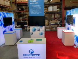 RENTAL: RE-9203 Island Design with Gravitee Storage Tower @ 42" x 42” x 142.5" H with Locking Door, (4) LED Arm Lights, (2) 96" W x 96" H Double-Sided Lightboxes, (4) Large Monitor Mounts, (4) 55" Monitors, (4) RE-1575 Workstation Counters with White La