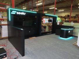 Custom Wood Inline Exhibit with Push Thru Backlit Logos, Large Monitor Mount, Opening for LED Video Tiles, RGB LED Accent Lights, and Custom Reception Counter with Locking Storage