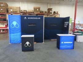 Modified GK-2013 Gravitee Inline Exhibit with (1) Backlit Graphic, Monitor Mount, SEG Fabric Graphics, Large Storage Closet, Workstation Counter, and GOD-1557 Backlit Reception Counter with Locking Storage